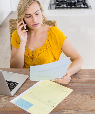 mujer contestando una llamada con unos documentos en la mano